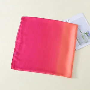 Detailansicht der weichen Textur und des pink-orangefarbenen Verlaufs des Seidenschals