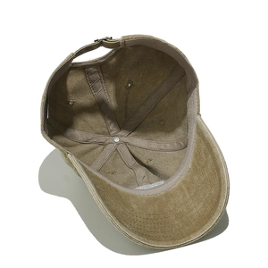 Detail of adjustable metal buckle and inner stitching on khaki cotton baseball cap