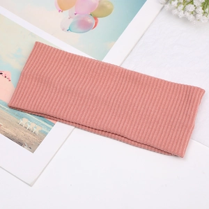 Detail showing the dusty rose ribbed knit texture of the wide knotted hairband