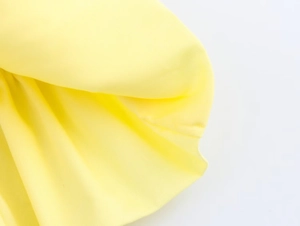 Detailed macro view of soft yellow knitted fabric texture and breathable mesh material