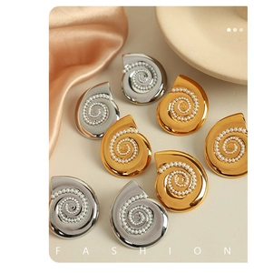 Detailed macro view of spiral seashell earrings in gold and silver with white pearls