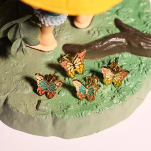 Macro shot of colorful enamel butterfly stud earrings with gold-toned finish detail
