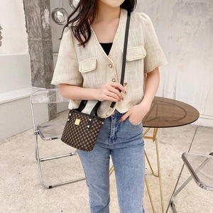 Classic floral pattern mini bucket bag with leather handles shown in a lifestyle setting