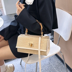 Detail of stone pattern leather bag featuring iconic bamboo handle and beige finish