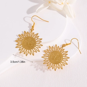 Golden sun face hollow drop earrings with vintage artistic design on white steps