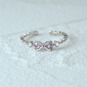 Detail of S925 silver ring featuring purple heart stones and butterfly bow design