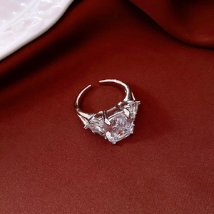 Detail of vintage silver open ring with large square zircon on red velvet background