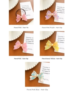 Detail view of acetate floral bow hair clips and elastic ties in pastel marble colors