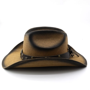 Detail of woven straw cowboy hat with leather band, studs, and bull head ornament