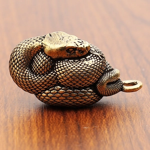 Vista macro di squame di serpente in ottone con finitura antica su superficie in legno