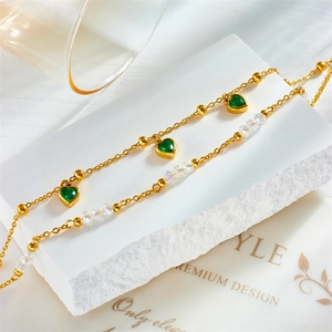 Vintage gold layered anklet with green heart pendants and faceted beads on stone base