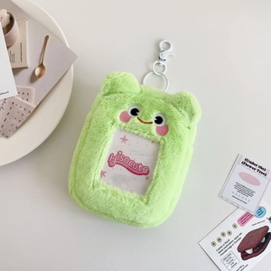 Detail of cute green plush frog card holder with transparent window and white clip
