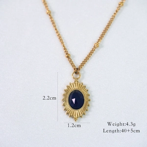 Detail of gold oval pendant with dark blue stone and precise size measurements