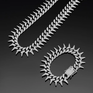 Macro detail of silver spiked Cuban link chain with luxury rhinestones on black background