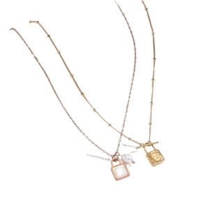 French style gold and rose gold shell padlock necklaces on minimalist white background