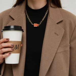 Close-up of a chunky gold chain necklace featuring a red Amour letter pendant for women