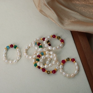 Elegant freshwater pearl and agate bead elastic rings on beige velvet with gold silk decor