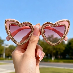 Pink heart-shaped sunglasses with sparkling rhinestone frame and gradient lenses