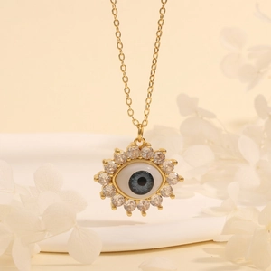 Detailed shot of gold plated sunburst Evil Eye pendant with blue iris and sparkling zircon