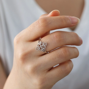 Silver hollow Wiccan knot stainless steel ring worn on hand in elegant setting