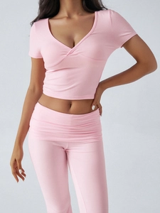 Détail du haut court rose Y2K à col en V et du pantalon évasé à taille haute