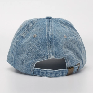 Detail der verstellbaren Messingschnalle an der Rückseite der hellblauen Jeans-Kappe