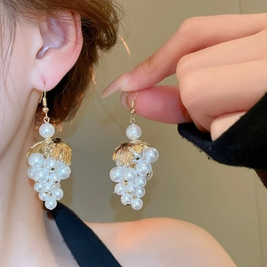 Detail of French grape cluster drop earrings with white pearls and gold leaf accents