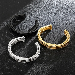Detail von dreischichtigen hohlen Titanstahl-Armreifen in Schwarz, Gold und Silber-Finish