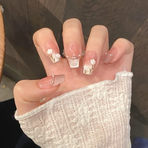 Detail of pink tulip press-on nails with 3D floral accents and delicate pearls
