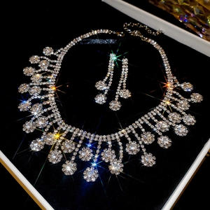 Close-up of sparkling rhinestone tassel necklace and earrings in a black velvet jewelry box