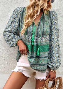 Detail of bohemian V-neck blouse with tassels and colorful paisley floral patterns