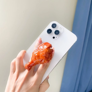 Realistic fried chicken leg shaped collapsible phone grip on a white smartphone