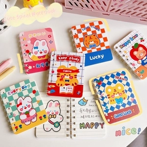 Close-up of portable cartoon coil notebooks in pastel colors with ruled inner pages