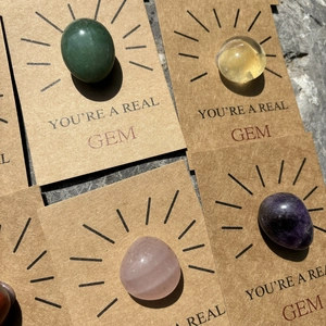 Greeting cards with round crystals in green, yellow, pink, and purple on stone background