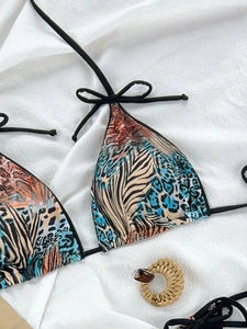 Detailed view of leopard print bikini top with blue color blocking and tie straps