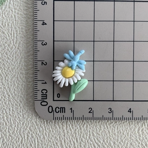 Vue détaillée de l'ornement en résine abeille et marguerite avec règle graduée