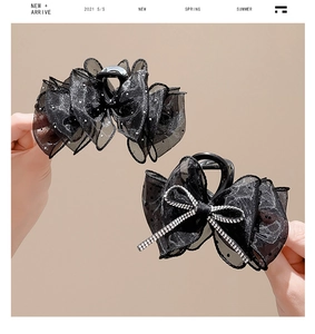 Vue détaillée de pinces à cheveux en dentelle noire avec strass et résille à pois