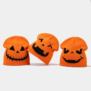 Three orange knit beanies with black Halloween pumpkin faces for winter festive warmth