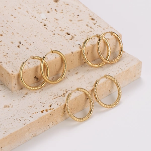 Three pairs of large gold stainless steel hoop earrings with textured vintage patterns