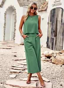 Outdoor shot of a woman wearing a green sleeveless top and matching wide-leg trousers