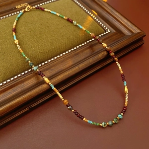 Close-up of bohemian beaded necklace with natural stones on a vintage velvet frame