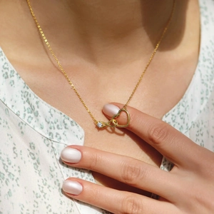 Macro shot of gold infinity heart necklace for women featuring a sparkling zircon stone