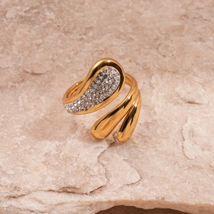 Macro shot of gold geometric ring with micro-pave cubic zirconia on a stone surface