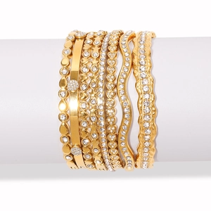 Close-up of seven gold-plated bracelets featuring heart and star motifs with pave zircons