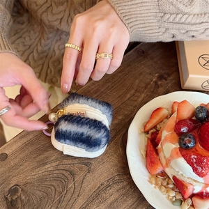 Blue and white striped plush AirPods case featuring a pearl zipper and Zakka woven label