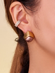 Close-up of geometric gold stud with rose pearl and sparkling zircon ear cuff set