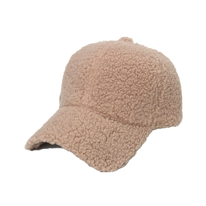 Close-up of thick beige Sherpa fleece texture on a warm winter baseball cap