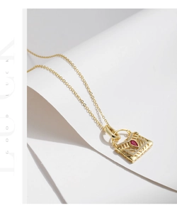 Vue détaillée du pendentif sac en argent S925 avec gemme rouge et pavé de cristaux