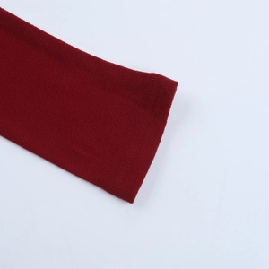 Primo piano dei polsini con doppia cucitura di un abito in maglia rossa testurizzata