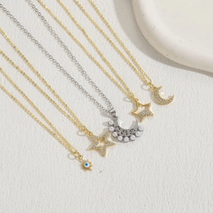 Detail of luxury necklace set with star, moon, sun, and pearl charms in gold and silver